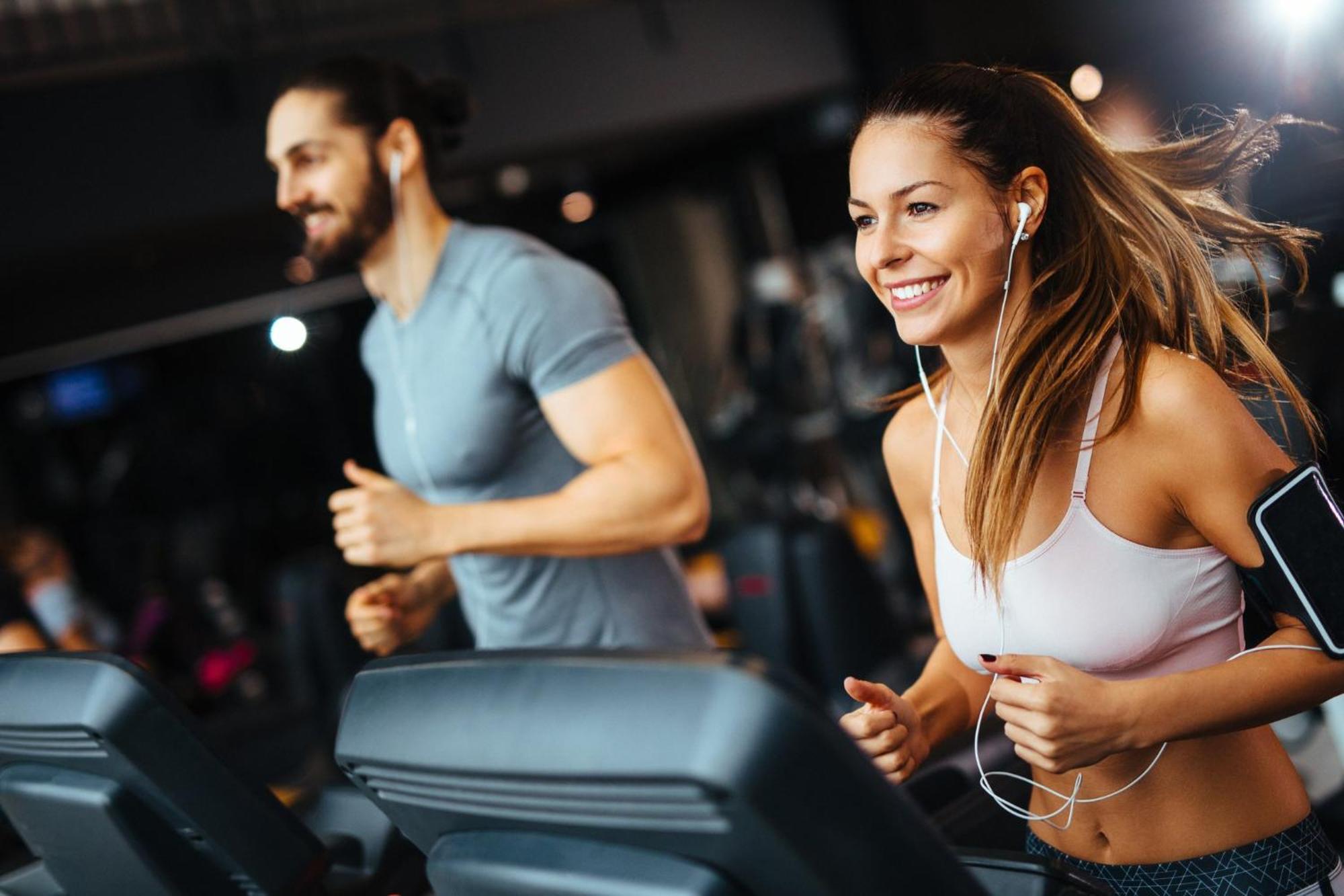 Crowne Plaza Changi Airport, An Ihg Hotel Singapore Exterior photo The photo shows two individuals running on treadmills in a gym. The woman, wearing a sports bra and workout leggings, has earbuds in and is smiling as she runs. The man, next to her, wears a fitted t-shirt and appears to be focused on his workout. Bo